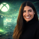 Asha Sharma, nova CEO da Microsoft Gaming, em um ambiente de escritório moderno com iluminação verde característica da marca Xbox.